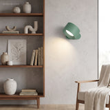 Rechargeable rotatable wall sconce mounted on a wall by a bookshelf