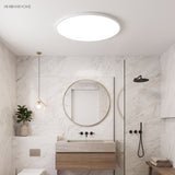 Round LED ceiling light in a marble bathroom above a vanity