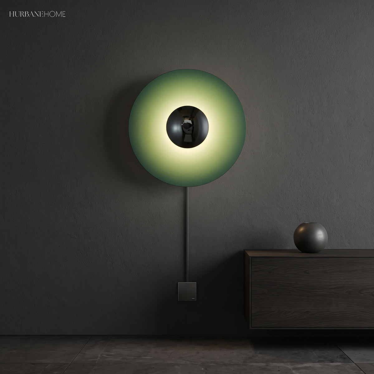 Green disc sconce with a chrome centre lit on a dark wall