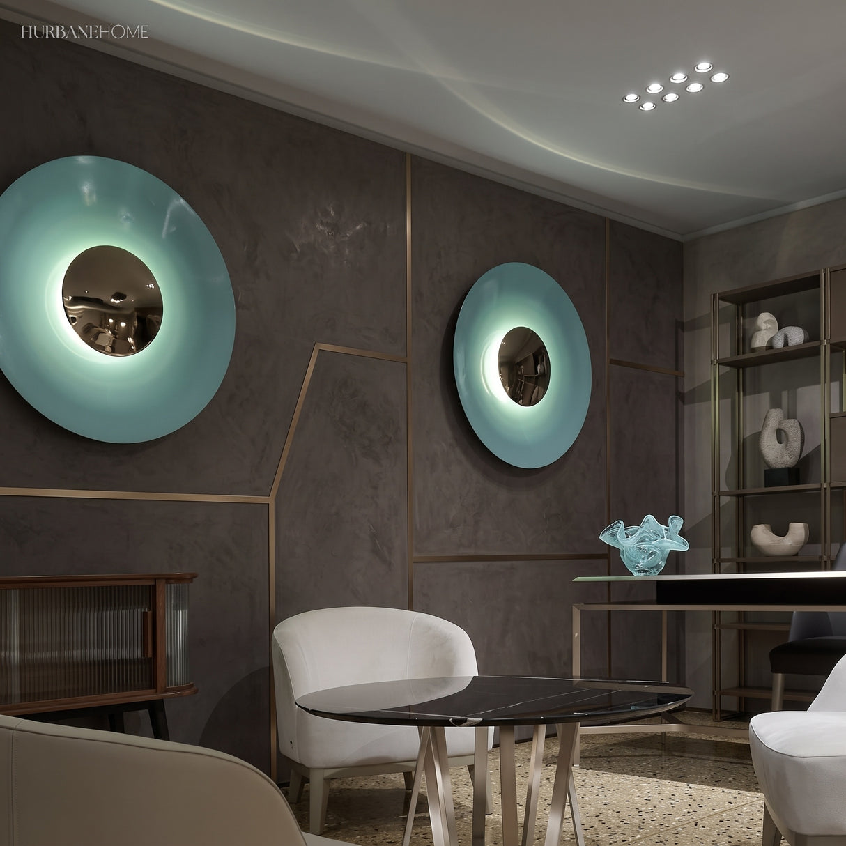 Two disc wall sconces in blue and green lit in a dining room