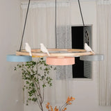 Round wood bird chandelier with colourful drum shades and slim black suspension cables