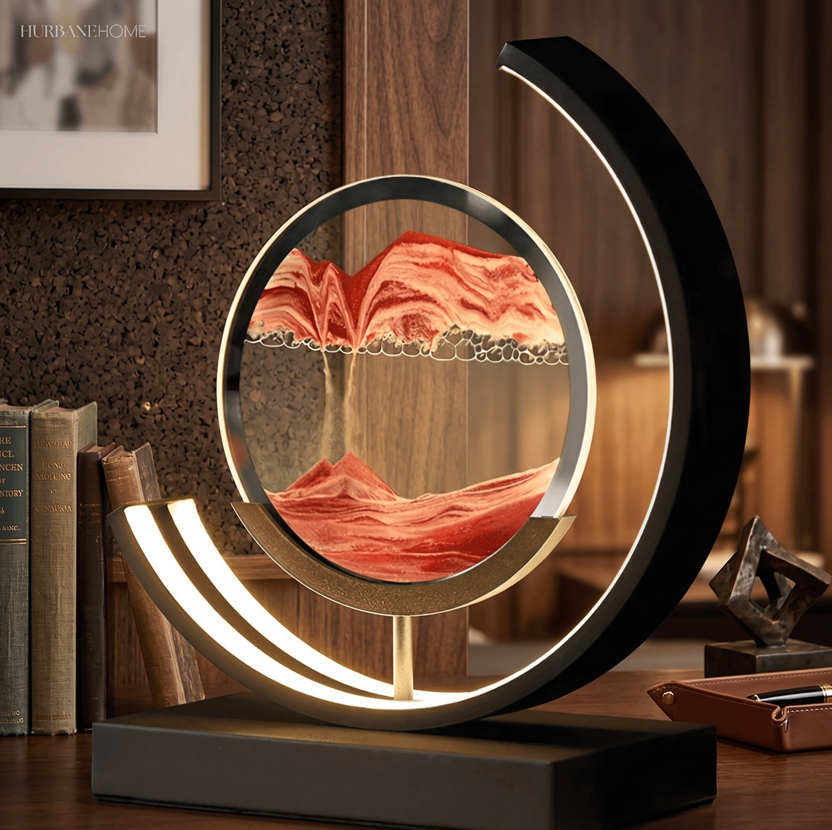 Sand art lamp glowing beside books and picture frame on desk