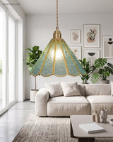 Scalloped glass pendant lit in a bright living room above a pale linen sofa