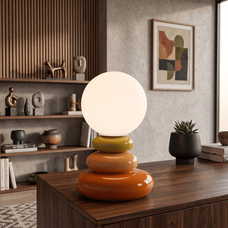 Orange stacked ceramic lamp with round opal shade on a walnut sideboard