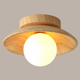 Close view of the wood disc shade and lit white glass globe