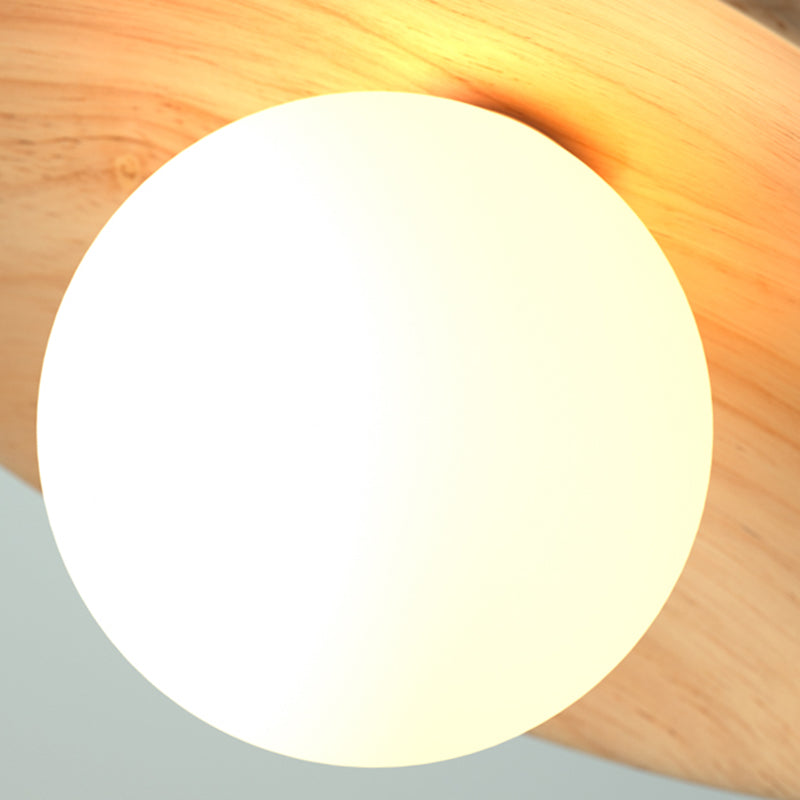 Close view of the white glass globe against the wood grain disc
