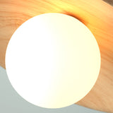 Close view of the white glass globe against the wood grain disc