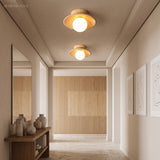 Two wood semi flush ceiling lights lit along a pale hallway