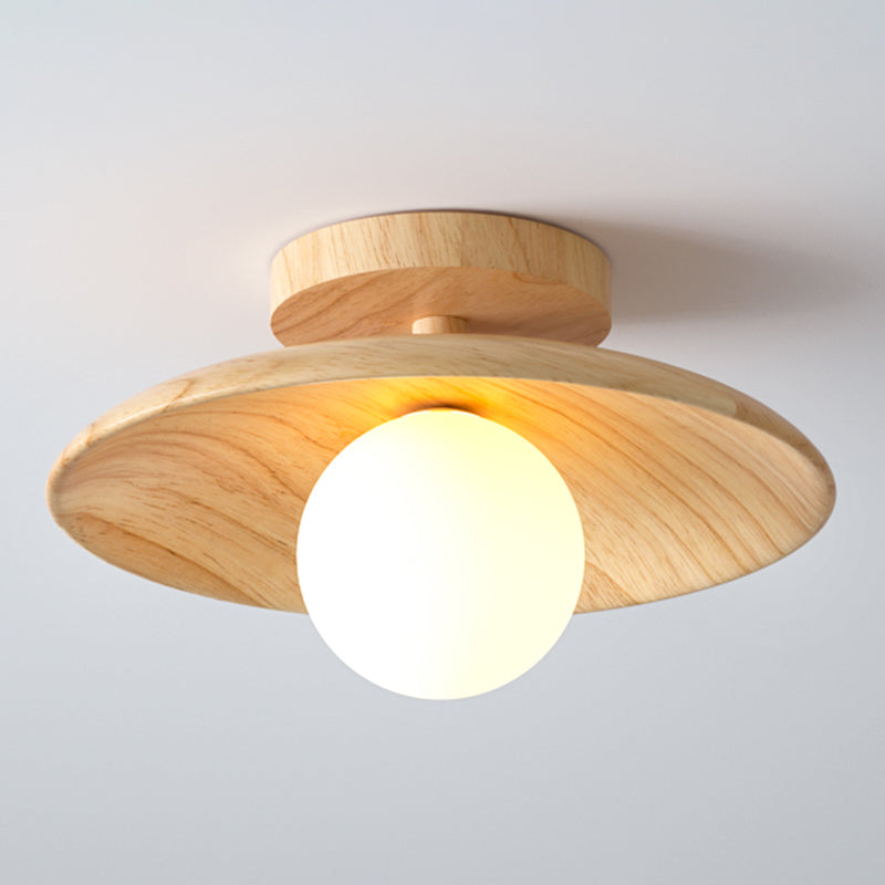 Wood disc ceiling light with the globe unlit on a pale ceiling
