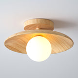 Wood disc ceiling light with the globe unlit on a pale ceiling
