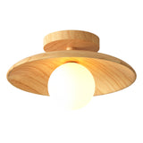 Wood disc ceiling light photographed straight on against grey