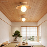 Two wood ceiling lights on a warm timber ceiling in a tatami room