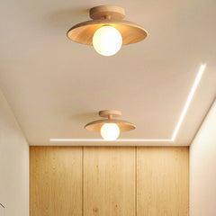 Two wood ceiling lights lit in a hallway with a timber wall