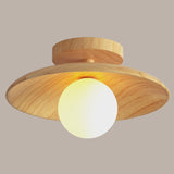Wood ceiling light with the globe glowing warm below the disc