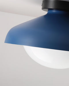 Blue dome ceiling light seen close up from below the opal glass globe