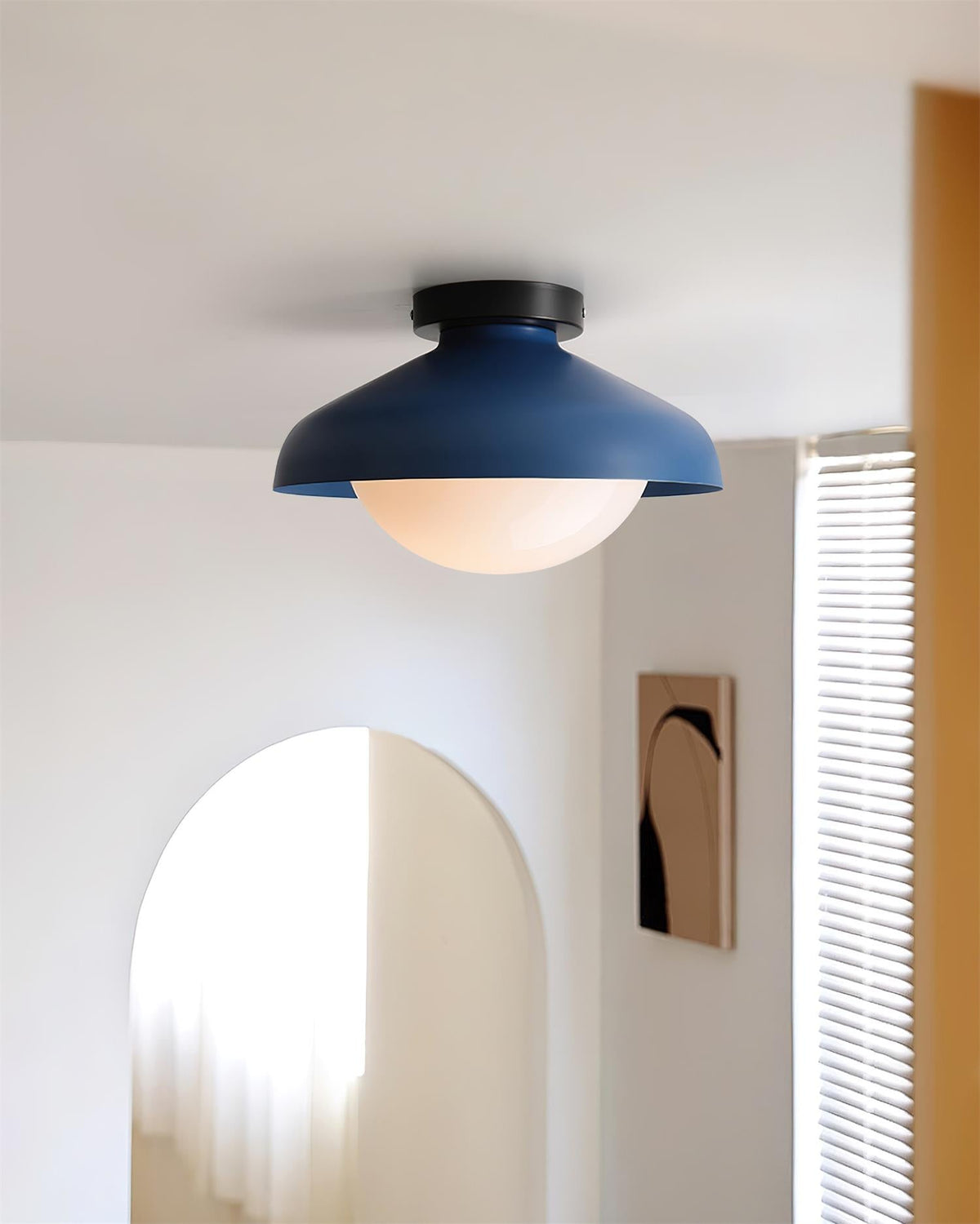 Blue dome ceiling light above an arched doorway in a white hallway