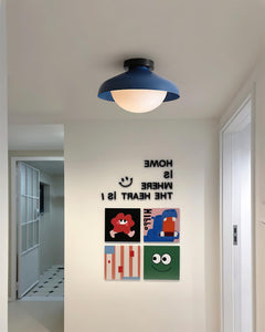 Blue dome ceiling light in a hallway with children's posters on a white wall