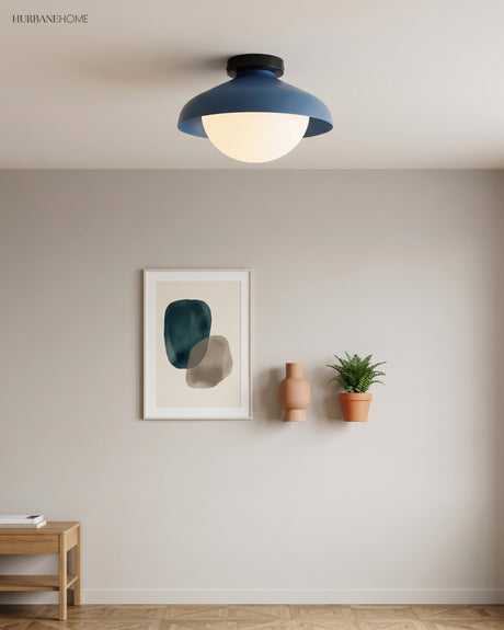 Blue dome ceiling light on a white ceiling above framed art and potted plants