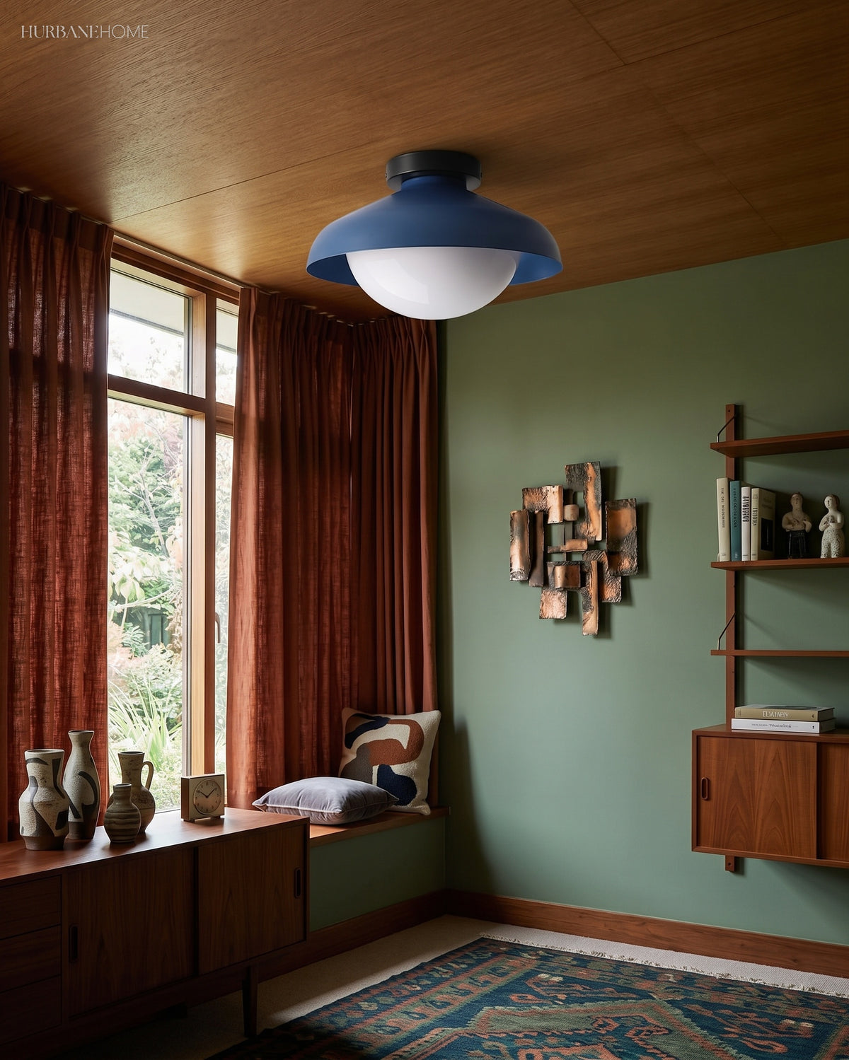 Blue dome ceiling light in a green study with a window seat and pottery