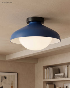 Blue dome ceiling light in a living room with artwork and open bookshelves