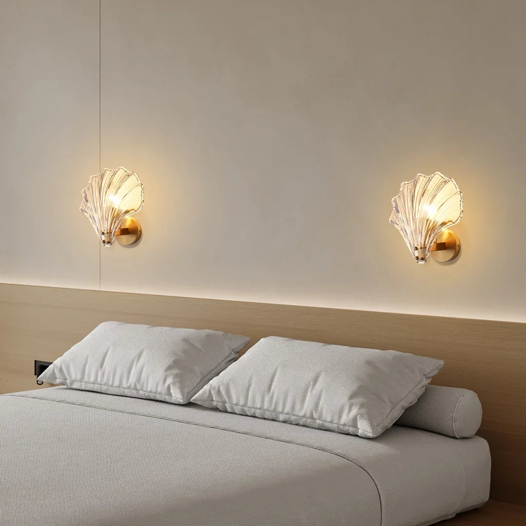 Amber shell wall sconce lit warmly against a soft coastal toned wall
