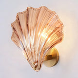 Amber shell glass wall sconce lit against a soft neutral background