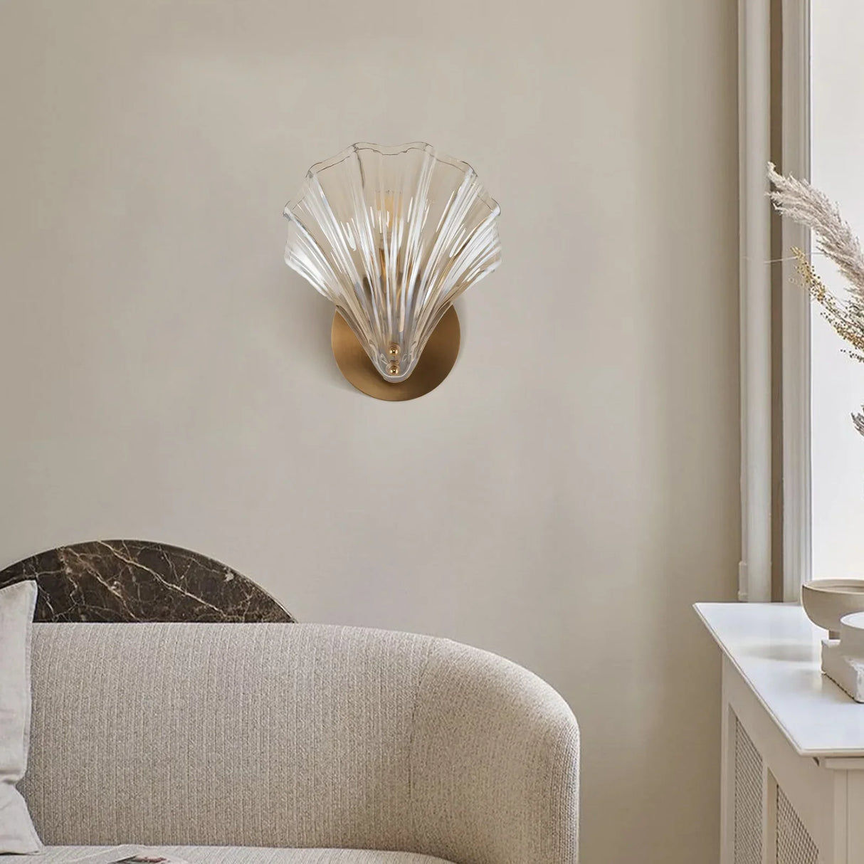 Amber glass shell sconce highlighting the fan shaped scallop outline