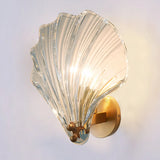 Transparent glass shell shade variant on the brass wall sconce base