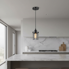A single black pendant light with a wire cage shade hangs over a modern kitchen island with a white marble countertop and backsplash.