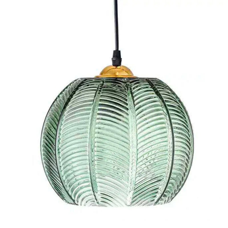 Single green palm leaf glass globe pendant shown as an eco friendly boho decor piece
