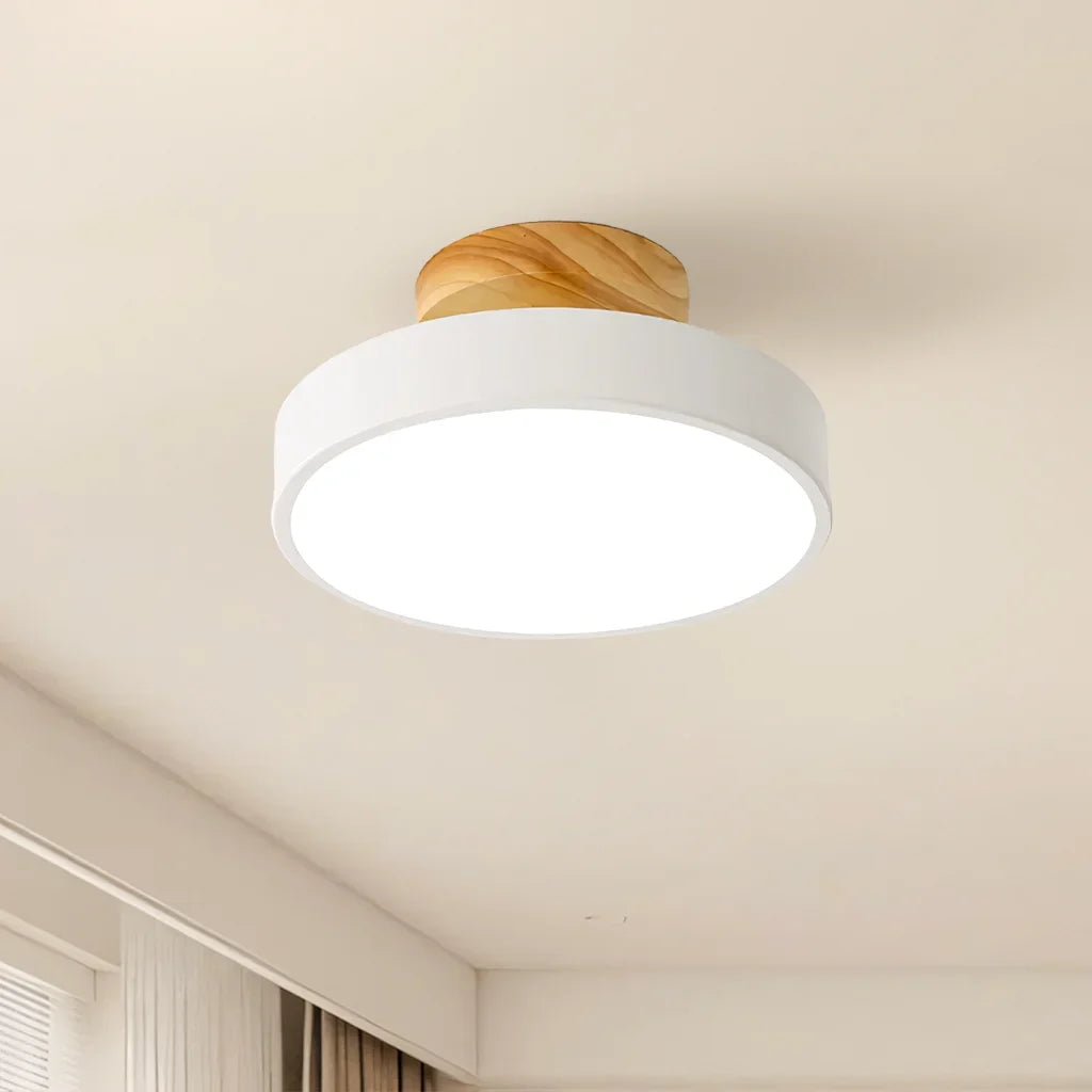Natural wood finish ceiling light shown against a plain studio background from below