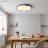 Grey flush mount ceiling light above a timber dining table