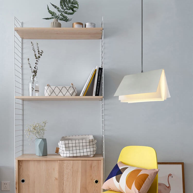 White book shaped pendant light hanging beside a shelving unit