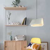 White book shaped pendant light hanging beside a shelving unit