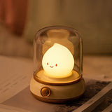 Cream based night light standing on an open magazine with warm light on the page