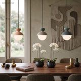 Row of small pendant lights over a dining table styled with white orchids