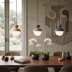 Row of small pendant lights over a dining table styled with white orchids