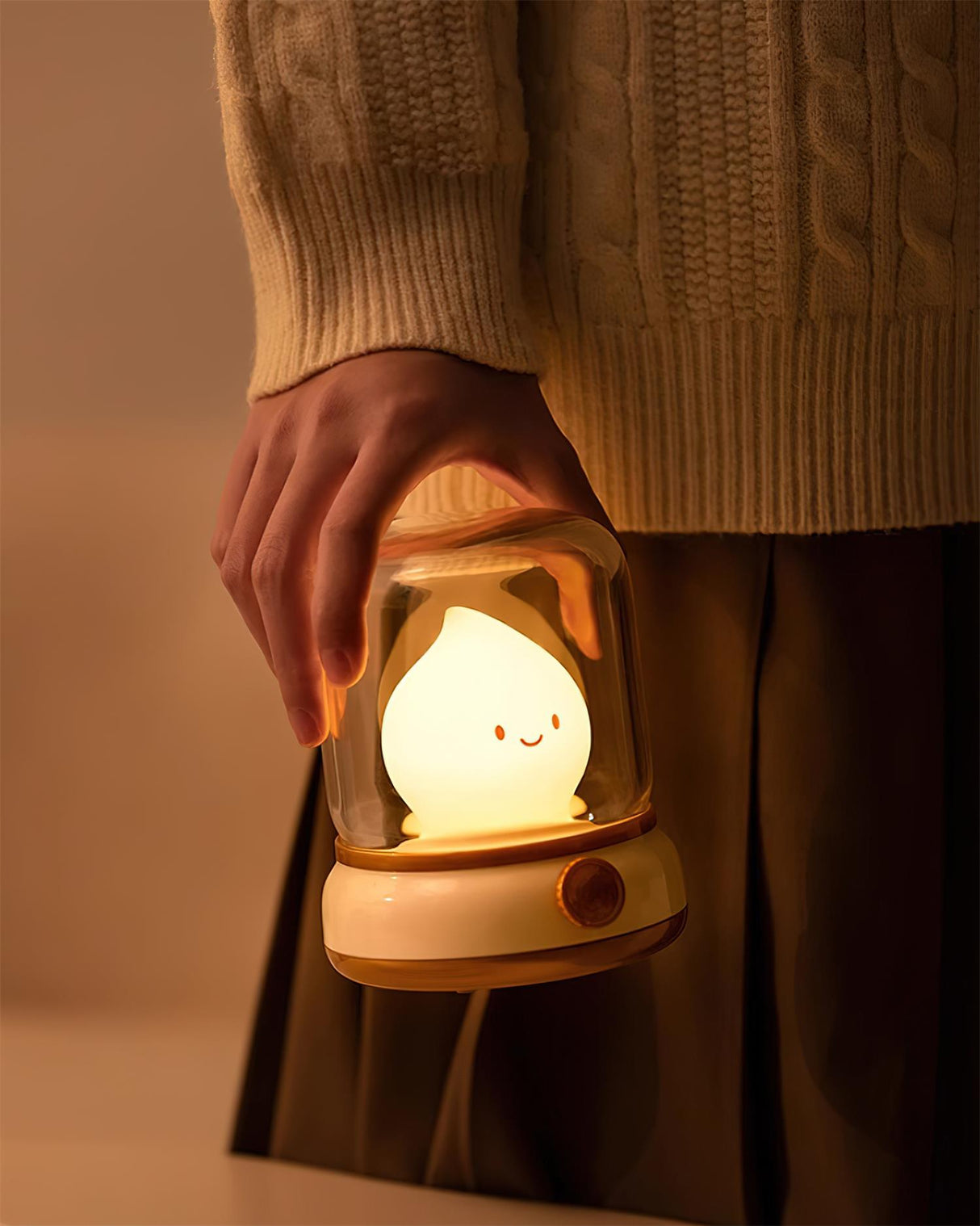Lit night light held close against a cream cable knit jumper