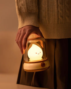 Lit night light held close against a cream cable knit jumper