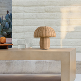 Small rattan table lamp shown for scale on a neutral backdrop