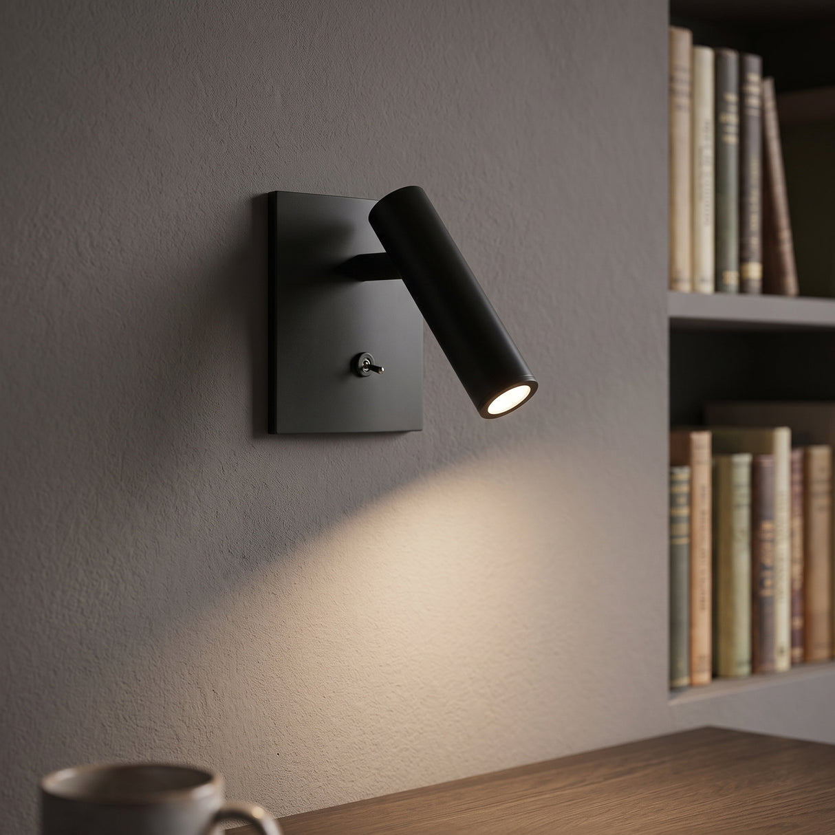 Black square LED wall sconce with switch beside a bookshelf
