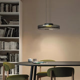 Smoke grey glass pendant light over a black table beside a bookshelf