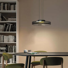 Smoke grey glass pendant light over a black table beside a bookshelf