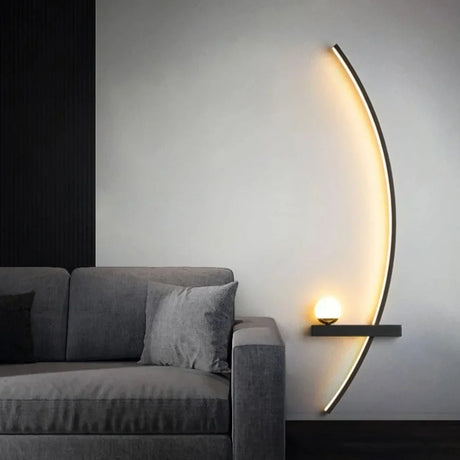 Linear wall sconce lighting a wall above a grey fabric sofa