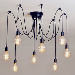 Black spider chandelier with eight cables and bare bulbs on a white ceiling