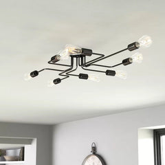 Black sputnik chandelier with bare bulbs seen against a white ceiling