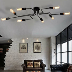 Black sputnik chandelier lit on a white ceiling in a brick walled loft