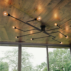 Black sputnik chandelier fixed to a timber clad ceiling by a window