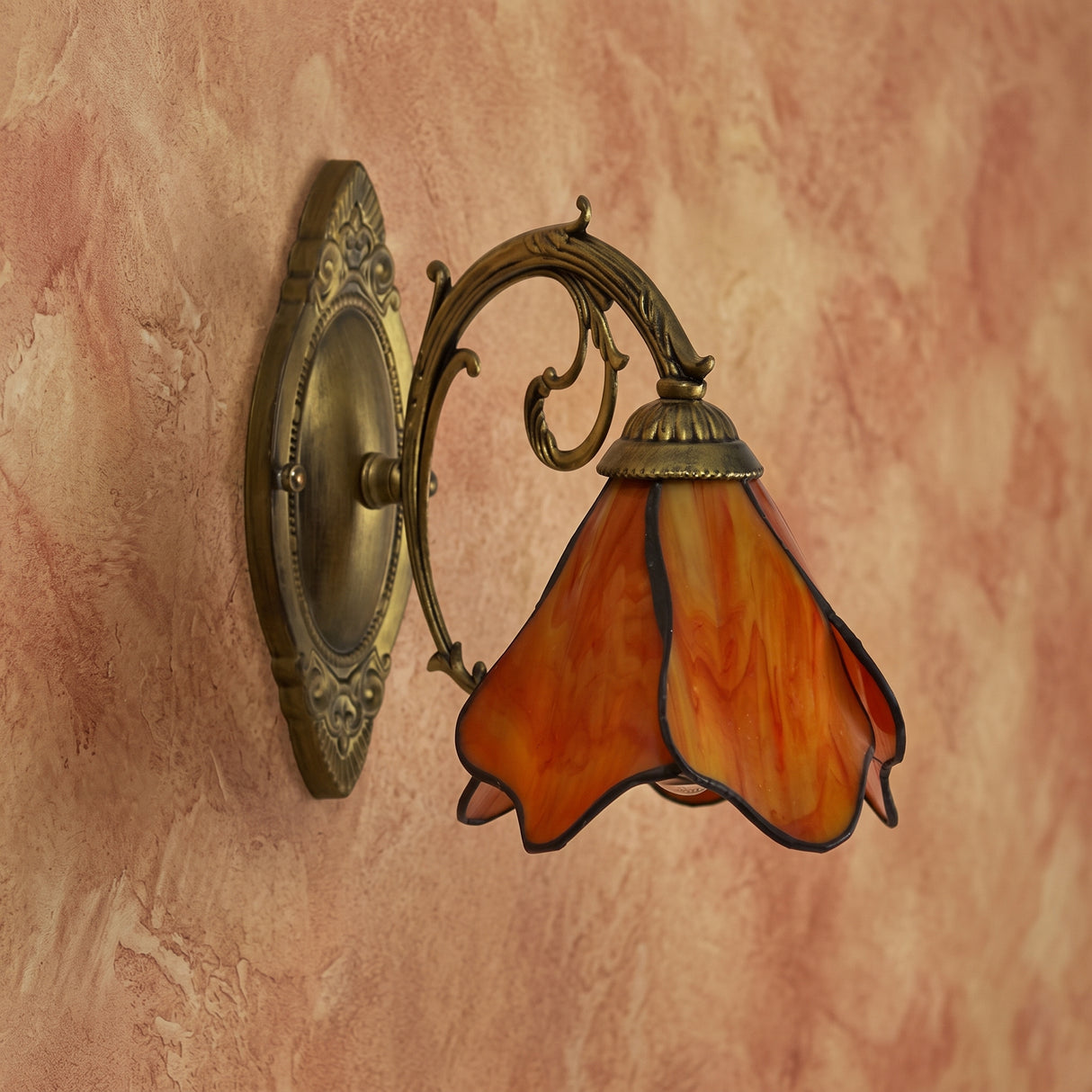 Amber petal stained glass wall sconce on an antique bronze oval backplate