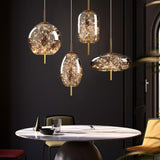 Four starry LED pendants in different glass shapes above a round marble table